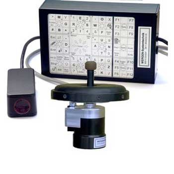 Flat rectangular black box with a computer screen. Wires are protruding from the computer's back, connecting to a joystick in front of the screen, and there is an infrared device on the left. 