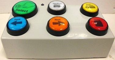 Large white, rectangular box-like device with two rows of three large colored buttons.