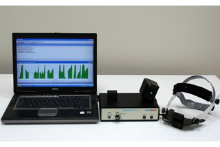 A black, open laptop shown next to two black medical devices. The laptop is displaying a green histogram.