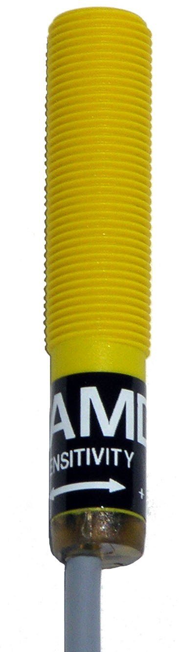 A yellow cylindrical device with a gray cord on the end.