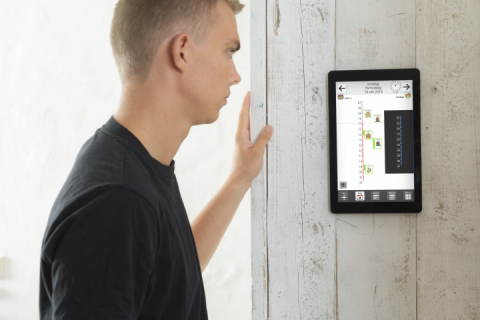 A tablet featuring the MEMOplanner screen hung on a wall.