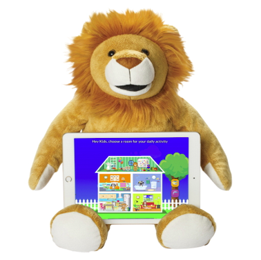 Bluebee Pal Leo the Lion is a plush brown lion with an orange/brown main, black round eyes, white footpads and a prominent white muzzle with a brown nose and black mouth. He is shown sitting with an iPad in his lap that has a screen featuring a blue background and a cross-section of a house, white picket fence and brown tree with a green bough.