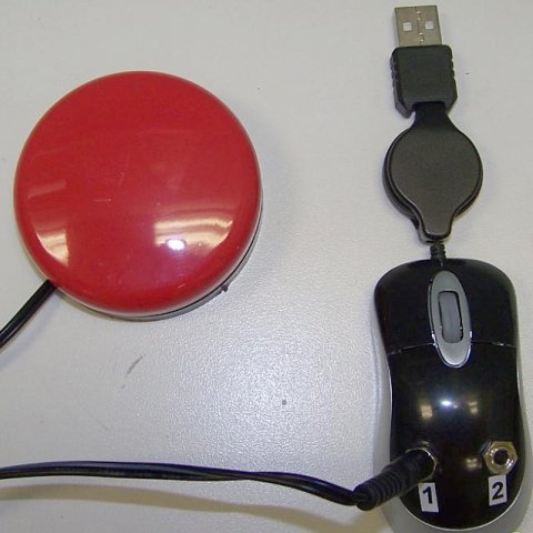 A black mini SwitchPort which appears like a computer mouse attached to USB cable. It has two input ports; a red switch is attached via left input port.