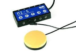 Small, rectangular black wired interface with one yellow switch attached to one of its 5 ports.