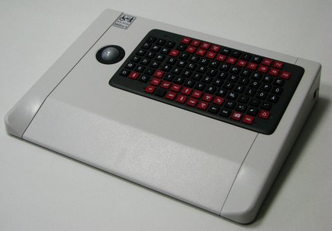 Square, white device with small, black keyboard on right and small trackball on left.