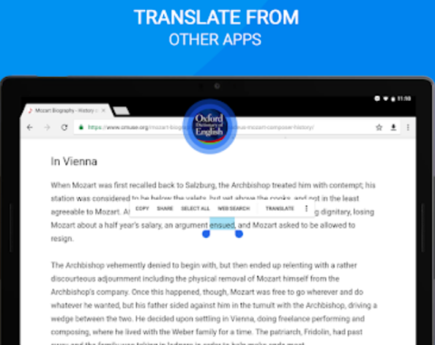A webpage on a tablet regarding a bio of Mozart. Also at the top, the center is a circle icon of the Oxford English dictionary, outlined with a blue haze. In the paragraphs that follow, a word is highlighted in a blue haze. The tagline states: translate from other apps.