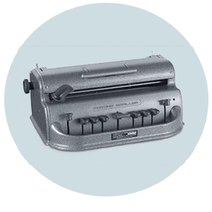 A gray brailler with a typewriter-like front with control keys and printing slit.