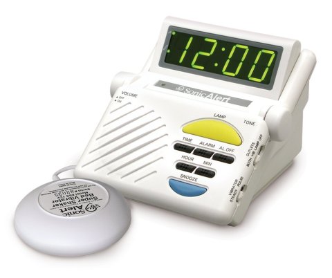 White device with digital clock, control buttons, speaker, and display.  A round white device attached by wire to the main unit.