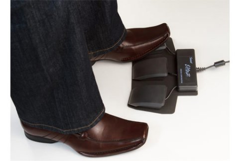 A foot is shown a black foot pedal (one of three).