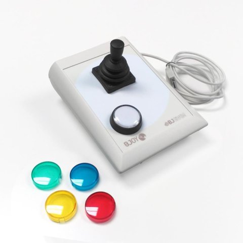 A white rectangular device a white button on the bottom left and a joystick at the top and green, blue, red, and yellow keyguards to the left of the device. 