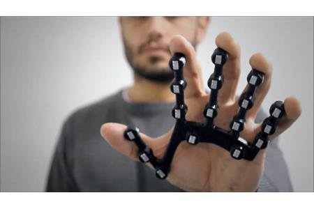Five pronged device with buttons that fits in palm of hand, prongs correspond with 5 fingers.