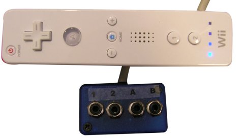 Wii controller connected on its left side and connected to a 4-port switch adaptor.