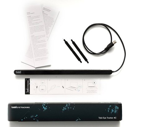 Eye tracking bar with input cable extending from right edge with two mounting brackets and three rectangular instruction pamphlets above the black packaging box.