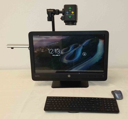 Monitor and wireless keyboard and mouse. Monitor has a camera mounted by an arm extending from top of monitor.