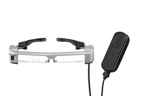 Wearable device resembling a pair of narrow goggles. The device is medium-grey in color. Also shown is a medium-sized, rectangular, and black device that is attached to the glasses by a cord.