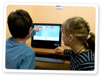 Two children interacting with Azahar on tablet.