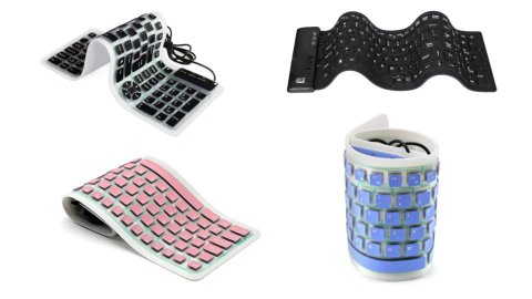 Various models of flexible keyboards. They resemble standard keyboards in layout, but they look as thin as an iPhone and are soft, rubbery mats, instead of standard, rigid keyboards. One model is black; another is light grey with black keys; a third model is light grey with light pink keys and is folded in half; the fourth model is light grey with light blue keys and is rolled into a tube for storage.