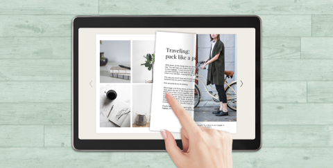 A hand turns the page of a digital magazine on a touchscreen e-reader device.