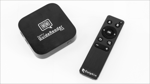 A small, black, square device next to a remote for operating the device.