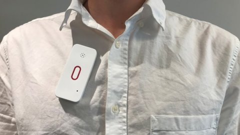 Wearable SpeakSee microphone, which is long, white, and oval/rectangular, and has a red oval in the center.