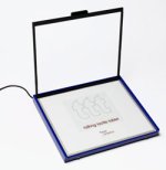 Large square electronic device with hinged clear cover in open position and white display surface displaying the product's logo.