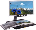 Widescreen, flat-panel LED display with a picture of a field on it attached to a desktop stand with an open book on it.