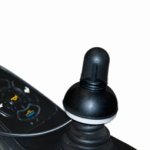 A black Bjoy Ring attached to the bottom of a wheelchair joystick.
