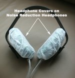 White headphone covers placed over black headphones on a grey background