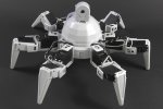 Robot in shape of spider with six legs, appears to have a camera protruding from center.