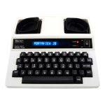 A TTY device resembling an electric typewriter. The keys and display panel are black, while the device body is off-white.