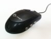Angled view of black mouse with cord trailing behind it and two plugs on its side.