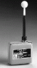 Photo of small, square gray device with a black post on the top right topped with a white round ball.