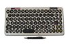 Large rectangular keyboard with black keys on beige background with pen in front.