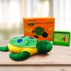 Photograph of plush turtle toy on a table with an orange box and a small green tablet device.