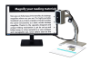 A monitor with black text magnified on a white background. A camera on an arm sits to the right and is focused on a document below it.