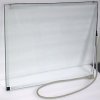 A square glass screen with a white frame and a cord attached to one of the edges.