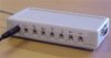 A rectangular device with eight ports for mini-jack jacks on one side and one port on the adjacent side.