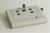 Rectangular device with joystick in center and two buttons on either side.