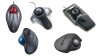 Five different models of trackball mice. They all resemble standard mice, except that there is a large trackball affixed to the top. Some trackballs are operated by the palm, so they are located in the center of the mouse. Others are attached where a user's thumb will lie when their hand is resting on the device. Two of the mice have a built-in palm/wrist rest. All the mice are either black or silver/grey. Two of the mice are wireless.