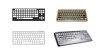 Various models of computer keyguards. They are rigid overlays that lay on top a keyboard and fill the gaps in between keys, framing and stabilizing them. Two models fit standard full-size keyboards, while two more fit compact, laptop-sized keyboards. One model is black; one is stainless steel; one is beige; and the fourth model is clear.