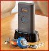 Black base with long rectangular device plugged in that has orange and blue buttons and one blue and one orange fob attached to keyrings.