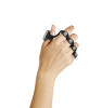 Women's forearm and hand with black strap-like device worn across the fingers and thumb.