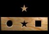 Black rectangular shape with a wood-like puzzle bar across the bottom with three openings for a star, a circle, and a square, and a matching star puzzle piece on top.